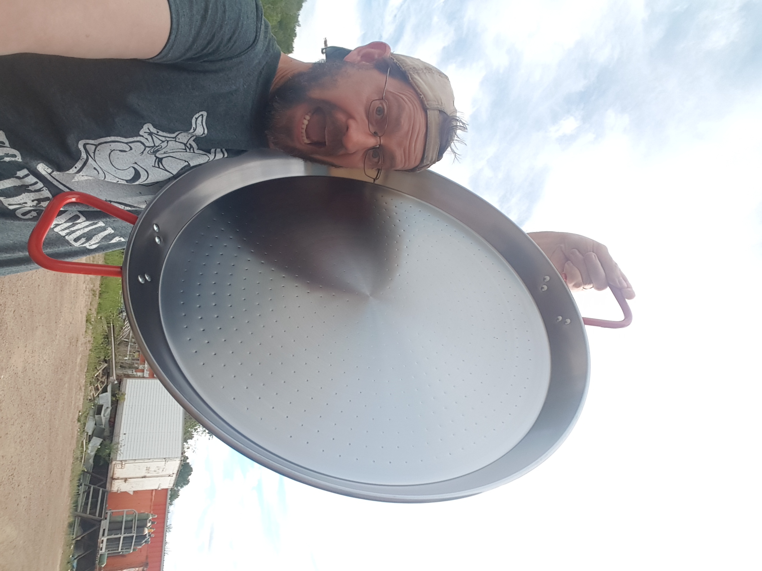 Greg holding an oversized cooking pan during event prep