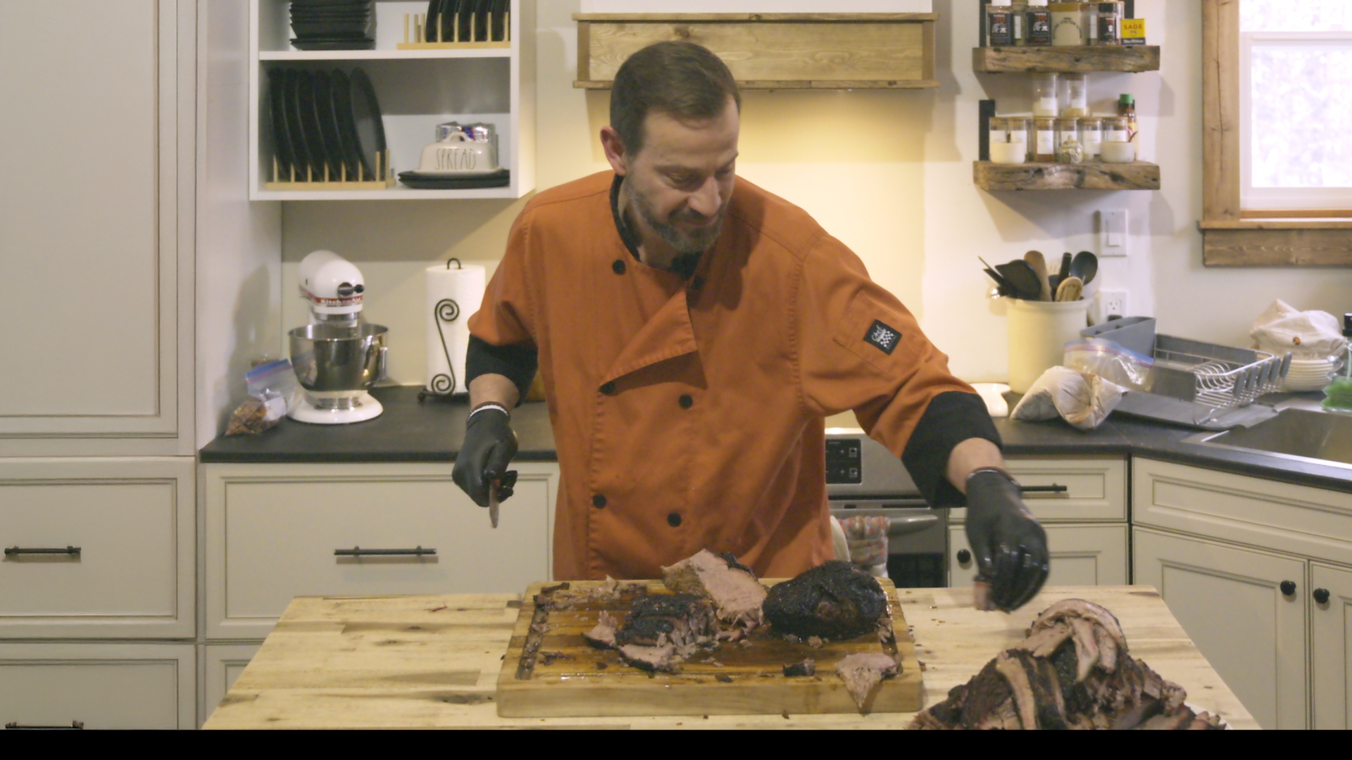 Greg slicing a brisket in the Back Forty kitchen for a YouTube video